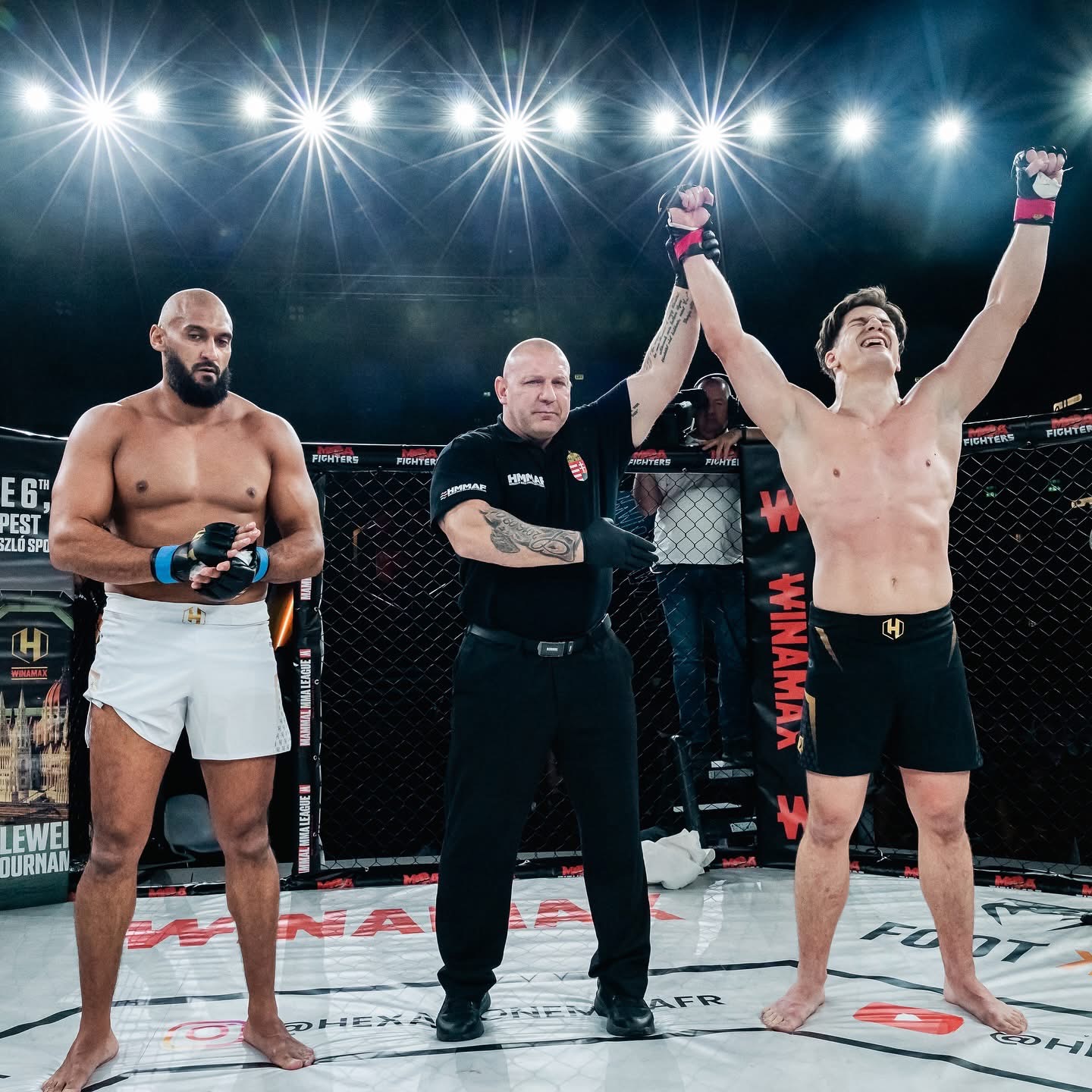 Zápasník Wolf Fight Club s dvíhanou rukou po víťazstve v klietke